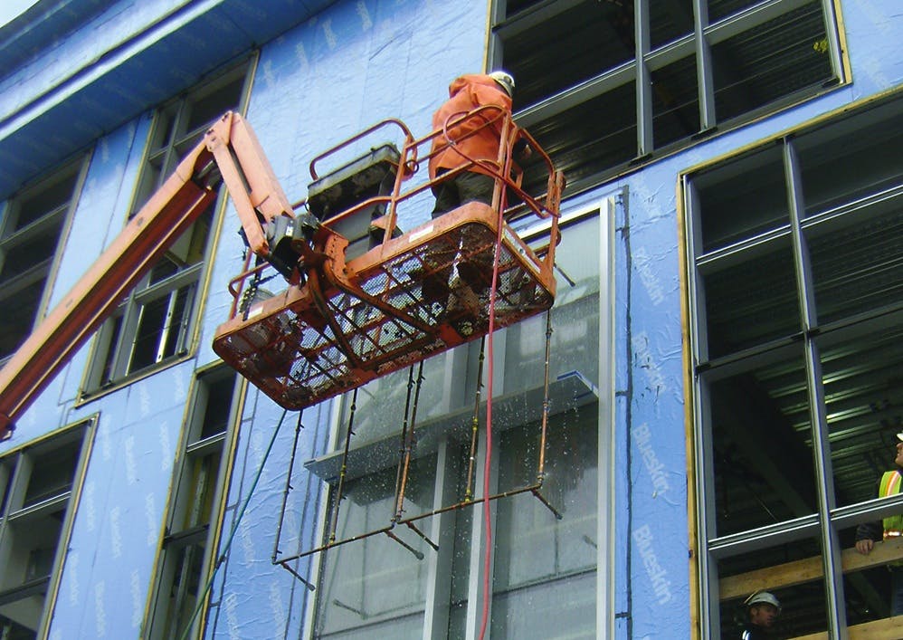 Water infiltration testing of an installed window prior to installation of adjacent cladding. Testing building enclosure systems