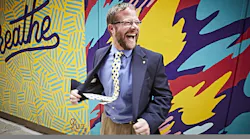 Under 40 philanthropist in front of mural