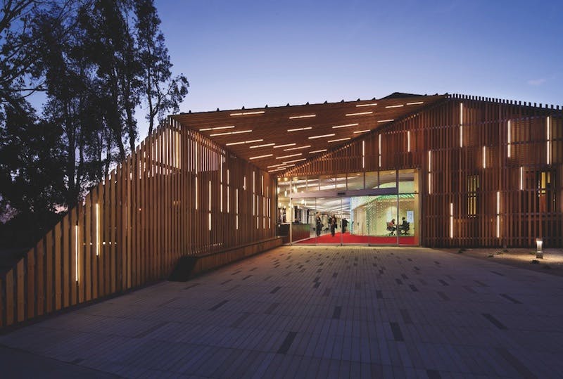 For a project at Claremont University Consortium, Claremont, N.Y., architect LTL and lighting designer Lumen Architecture used lighting to transform a steel-framed warehouse. An exterior slatted wooden screen is interspersed with LED strips, creating a striking nighttime effect. Photo: Michael Moran / Courtesy Lumen Architecture