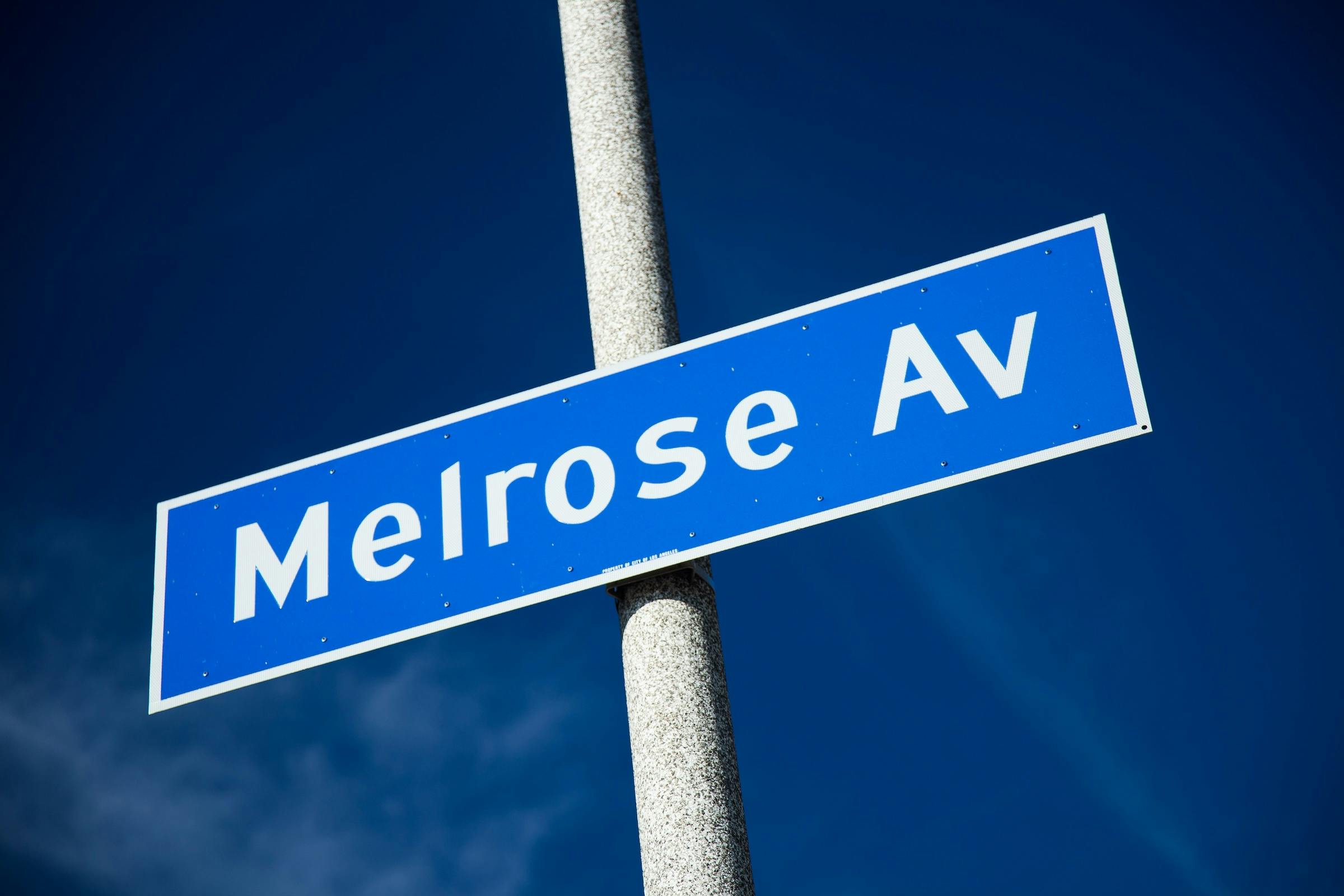 Outdoor daylight photo of Melrose Ave. sign with blue sky in Los Angeles. Photo: billnol via iStock