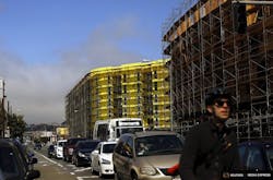 A bicyclist sits in traffic near a housing construction project in San Francisco. Photo: Reuters/Robert Galbraith A bicyclist sits in traffic near a housing construction project in San Francisco. Photo: Reuters/Robert Galbraith