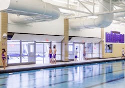 Fire-rated glass separation helps merge new and old pools into a single connected aquatics center Fire-rated glass separation helps merge new and old pools into a single connected aquatics center