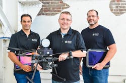 Three men standing with drove Three men standing with drove