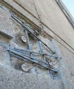 Cut and chipped concrete with exposed rebar and anodes Cut and chipped concrete with exposed rebar and anodes