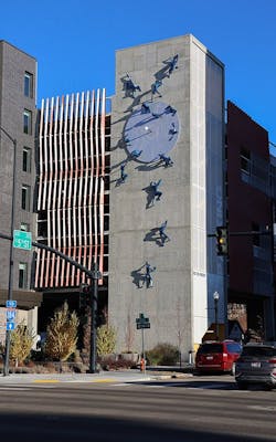 Metal figures scale building in life size public art installation Metal figures scale building in life size public art installation