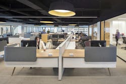 people sitting at desks in an open office people sitting at desks in an open office