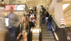 People on escalator in shopping mall People on escalator in shopping mall