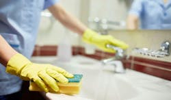 Janitor cleaning sink in hotel room Janitor cleaning sink in hotel room