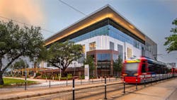A train on the railway tracks in front of adaptive reuse building A train on the railway tracks in front of adaptive reuse building