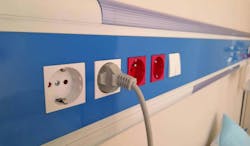 Power cord plugged into electrical outlet on insulated wall in hospital room Power cord plugged into electrical outlet on insulated wall in hospital room