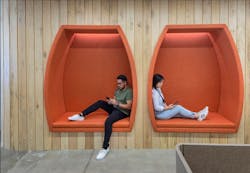 Contrasting bold brand colors with natural materials, banquette niches offer comfortable heads-down spaces for staff. Photo by SLAM Contrasting bold brand colors with natural materials, banquette niches offer comfortable heads-down spaces for staff. Photo by SLAM