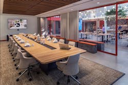 The ebullience of the café bar and lounge beams through double pane glass walls of adjacent meeting rooms. Photo by SLAM The ebullience of the café bar and lounge beams through double pane glass walls of adjacent meeting rooms. Photo by SLAM