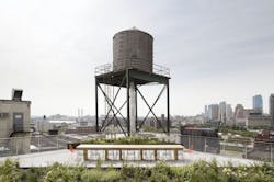 A conference table in front of an existing warehouse at the 20 Jay Street rooftop by James Corner Field Operations A conference table in front of an existing warehouse at the 20 Jay Street rooftop by James Corner Field Operations