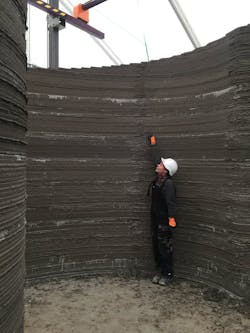 Standing next to a 3D printed wall of The BOD Standing next to a 3D printed wall of The BOD