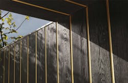 Gold metallic band between vertical siding boards Gold metallic band between vertical siding boards