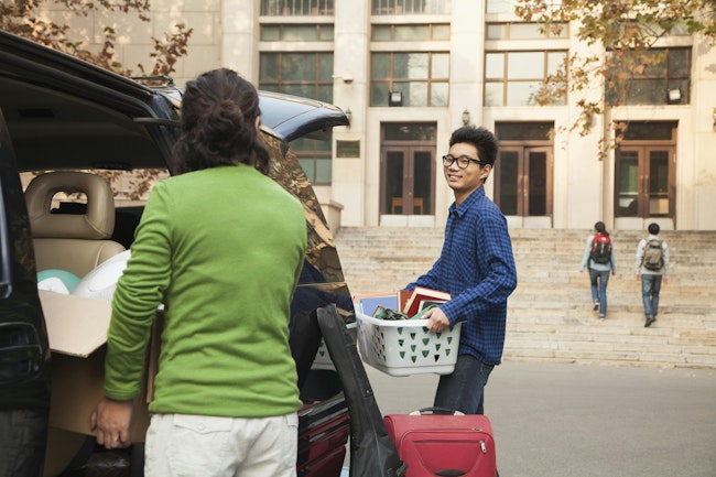 Young men moving into dormitory on college campus