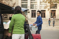 Young men moving into dormitory on college campus Young men moving into dormitory on college campus