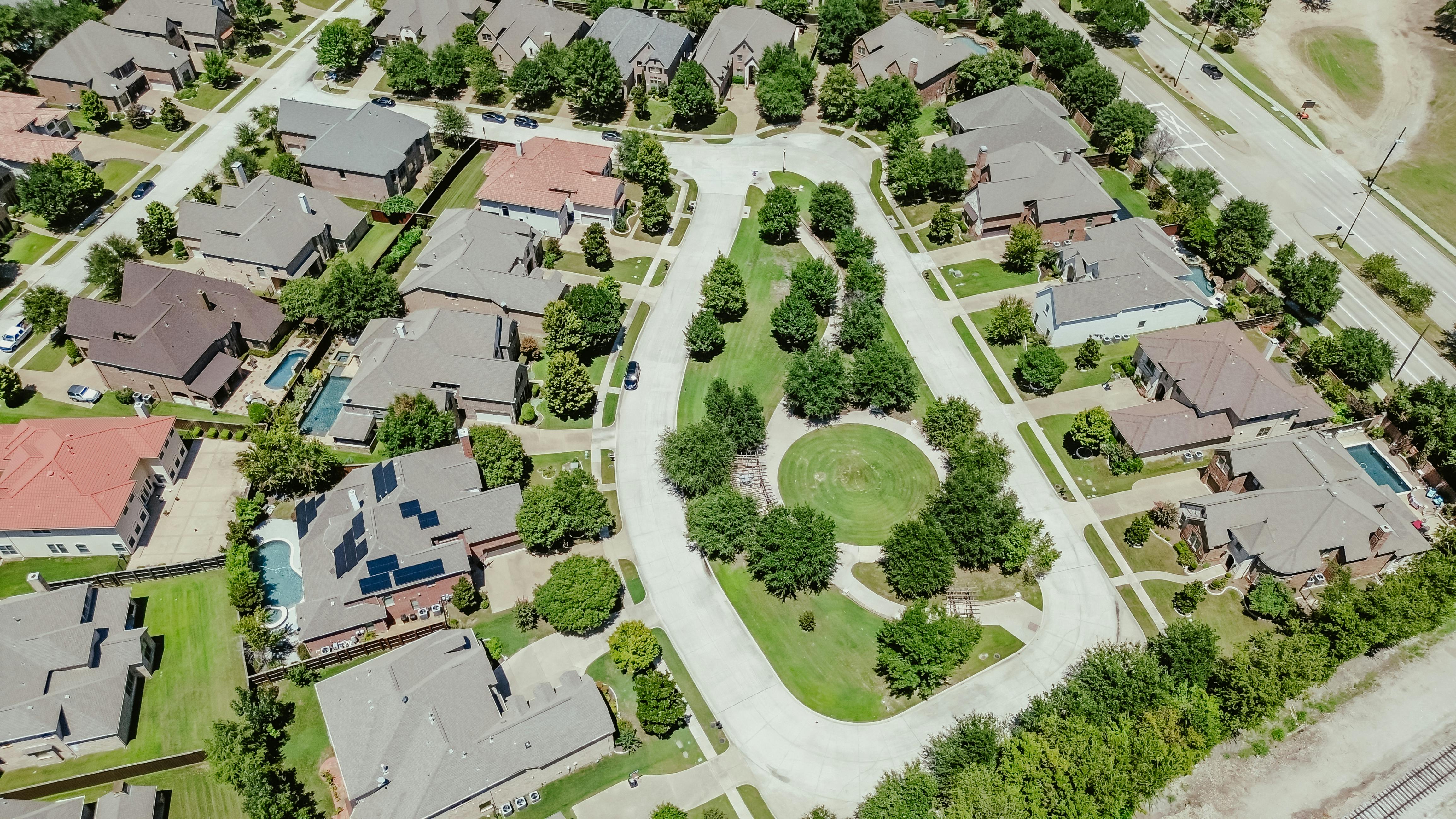 Colorful concrete roof tiles row of large two story suburban single-family houses swimming pools in upscale residential neighborhood Coppell, suburbs Dallas Fort Worth, well-trimmed landscape. USA