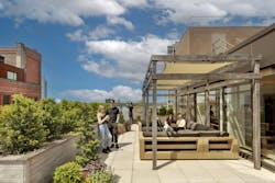 Rooftop terrace at office building workplace with people sitting outside Rooftop terrace at office building workplace with people sitting outside