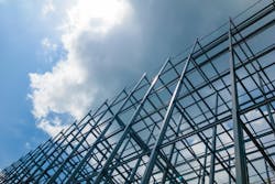 A large building of steel structure in the sky with sun and clouds. A large building of steel structure in the sky with sun and clouds.