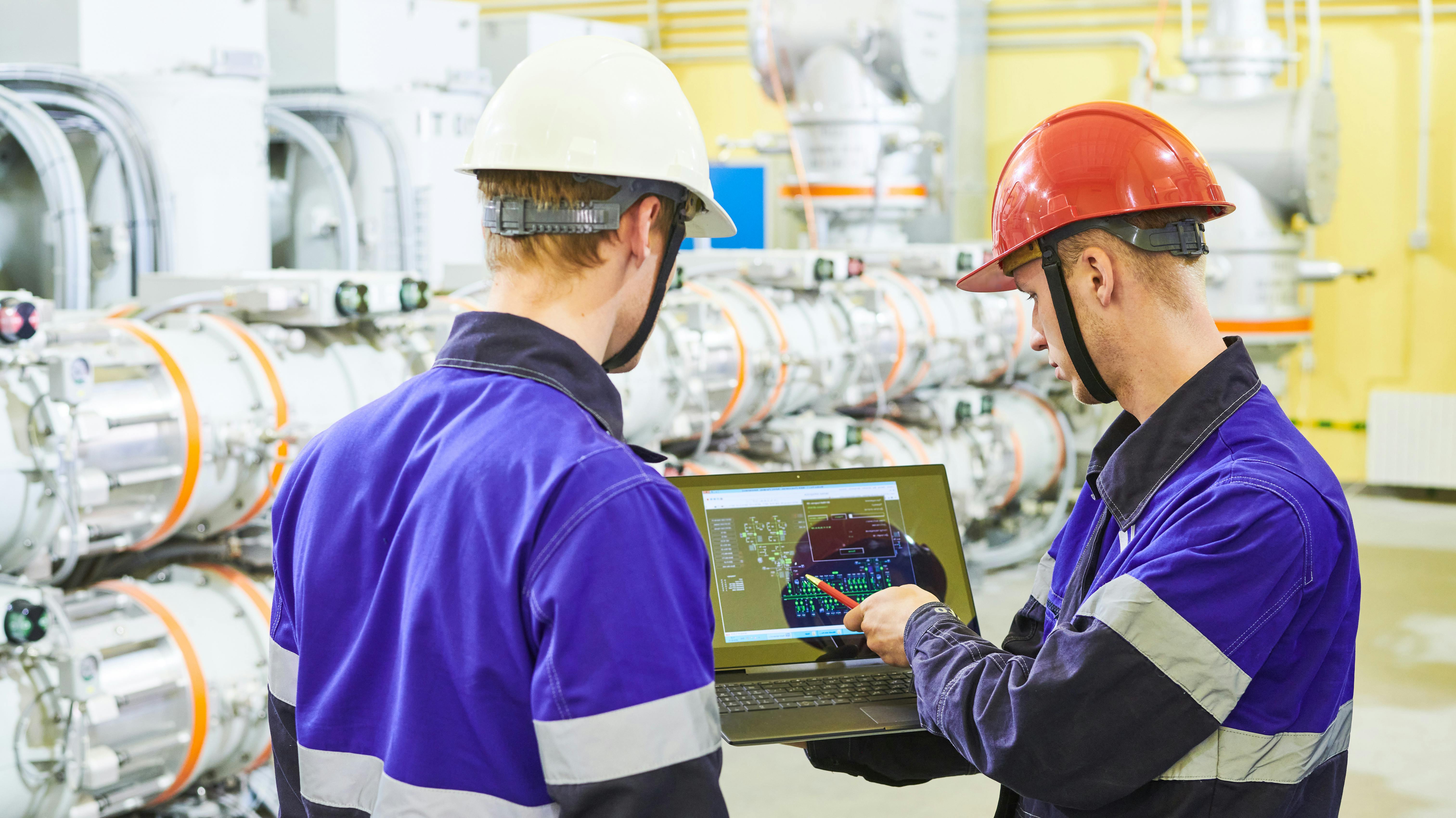 Industrial workers with tablet computer at power energy supply factory