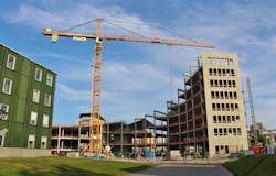 Construction site. A construction crane in the work to construct a new building. Construction site. A construction crane in the work to construct a new building.
