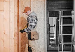 General Contractor at Construction Site. Caucasian General Contractor at Wooden Residential House Construction Site. Industrial Theme General Contractor at Construction Site. Caucasian General Contractor at Wooden Residential House Construction Site. Industrial Theme