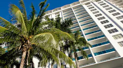 Miami condominium. Low angle view of condominium with palm tree in foreground, Florida, U. S. A.