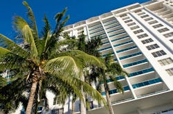 Miami condominium. Low angle view of condominium with palm tree in foreground, Florida, U. S. A. Miami condominium. Low angle view of condominium with palm tree in foreground, Florida, U. S. A.