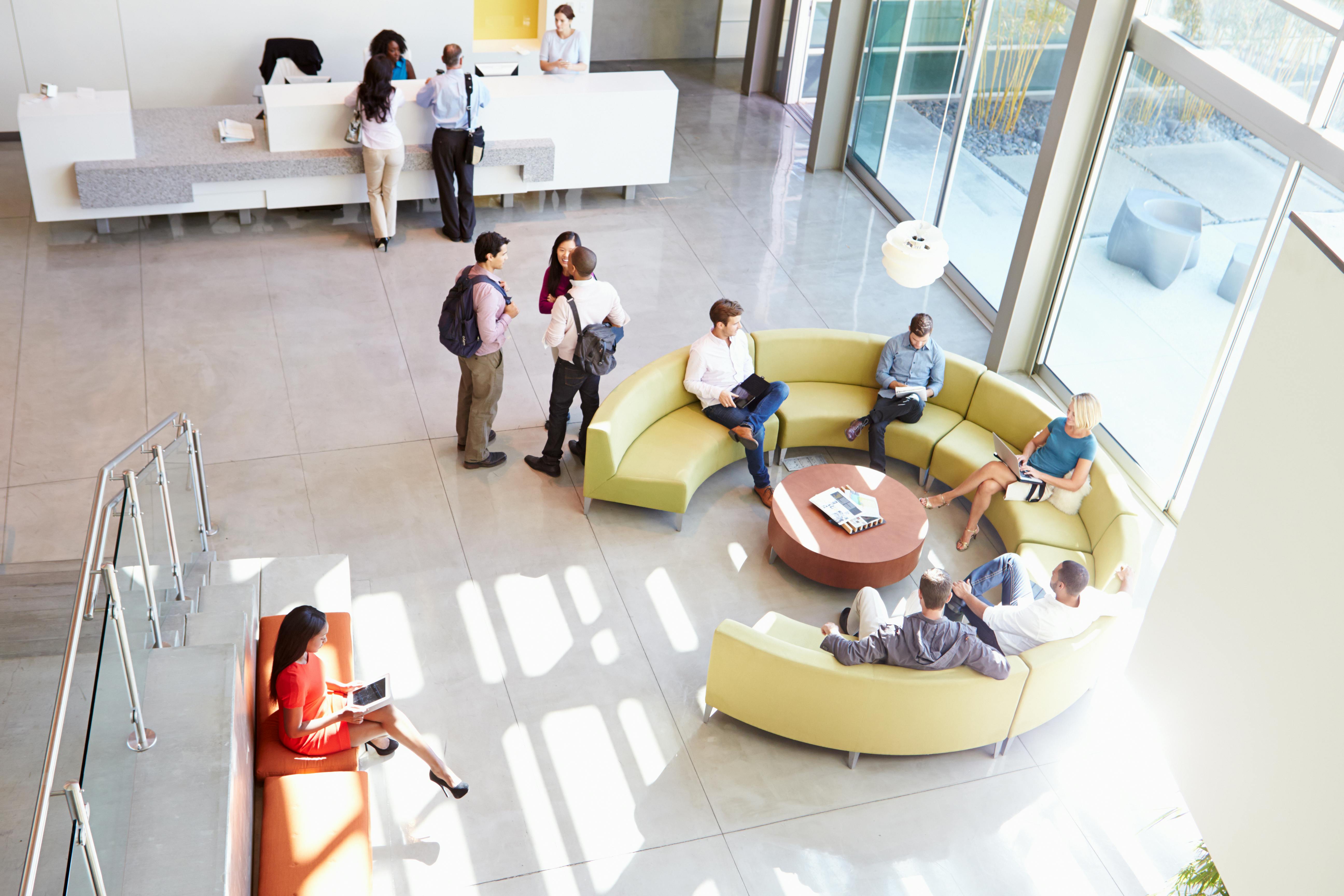 Reception Area Of Modern Office Building With People Overhead Shot