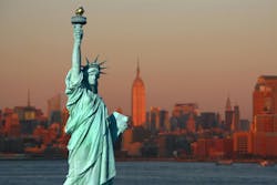 New York: The Statue of Liberty, an American symbol, with Lower Manhattan skyline at sunset in the background. Tourism concept photo. Liberty Island, New York City, USA New York: The Statue of Liberty, an American symbol, with Lower Manhattan skyline at sunset in the background. Tourism concept photo. Liberty Island, New York City, USA