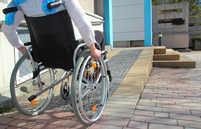 A Woman in a wheelchair using a ramp