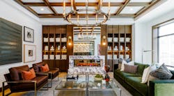 A stone fireplace anchors the resident club room at 619 North, where layered textures, warm wood tones and greenery create an inviting retreat A stone fireplace anchors the resident club room at 619 North, where layered textures, warm wood tones and greenery create an inviting retreat