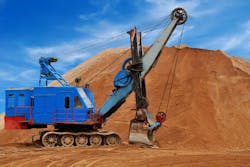 Heavy electric excavator in sandpit. Heavy digger electric excavator standing in sandpit with huge bucket on the ground Heavy electric excavator in sandpit. Heavy digger electric excavator standing in sandpit with huge bucket on the ground