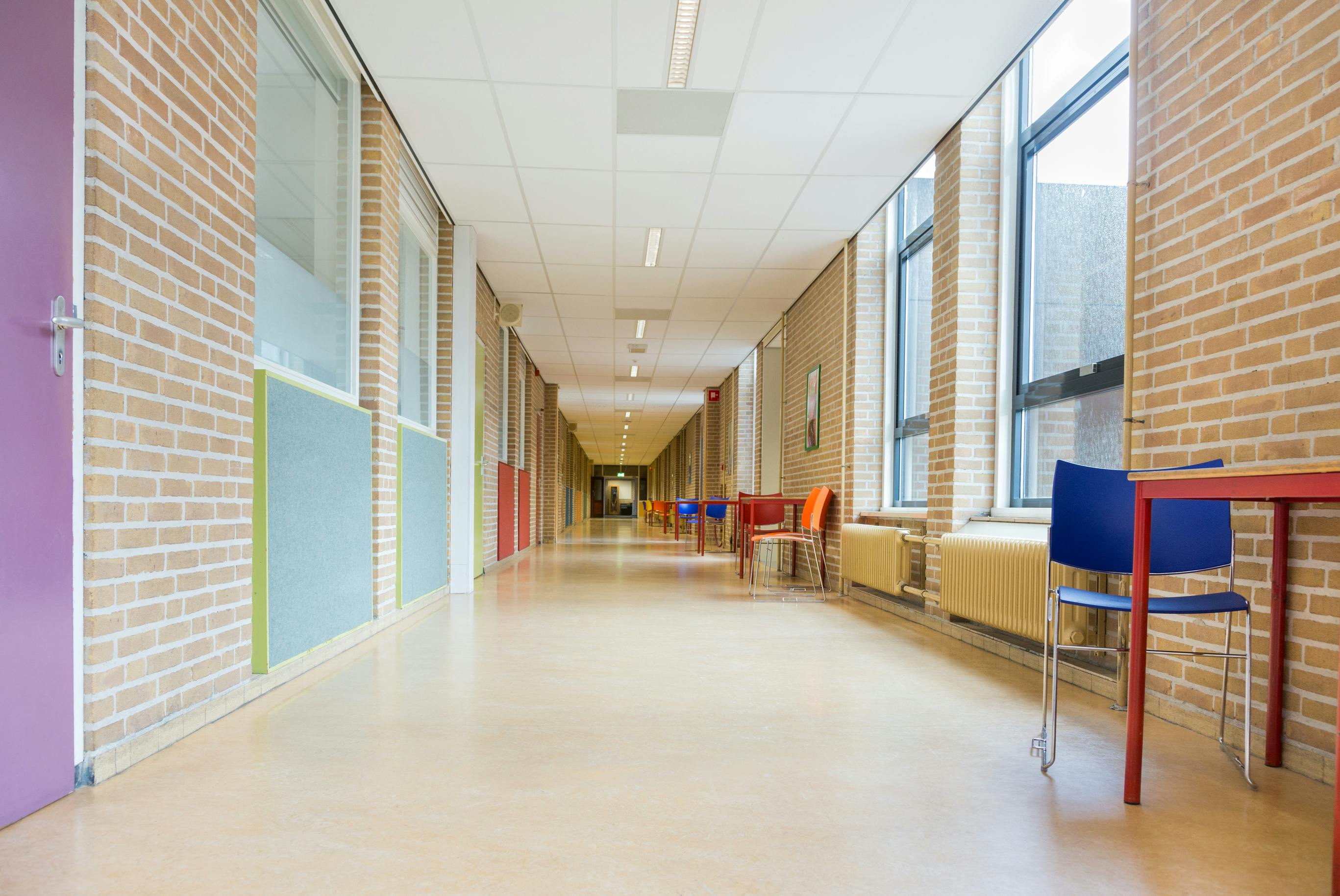Long corridor with furniture in school building.