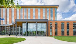 Front view of Clackamas County Courthouse featuring a red brick facade, tall entrance windows, landscaped grounds, and waving flags. Photo courtesy DLR Group Front view of Clackamas County Courthouse featuring a red brick facade, tall entrance windows, landscaped grounds, and waving flags. Photo courtesy DLR Group