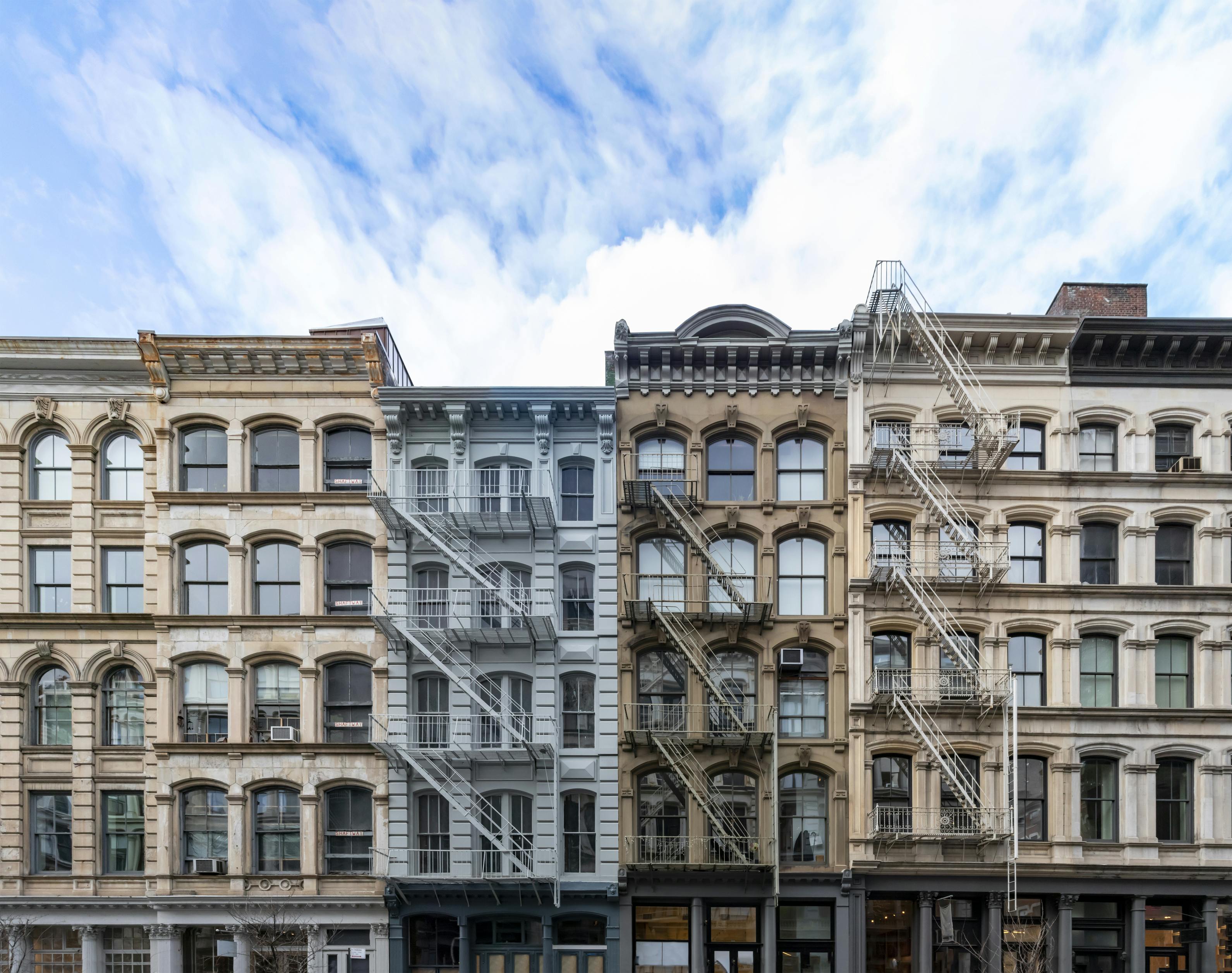 Exterior view of old apartment buildings in the SoHo neighborhood of Manhattan in New York City with empty blue sky background overhead