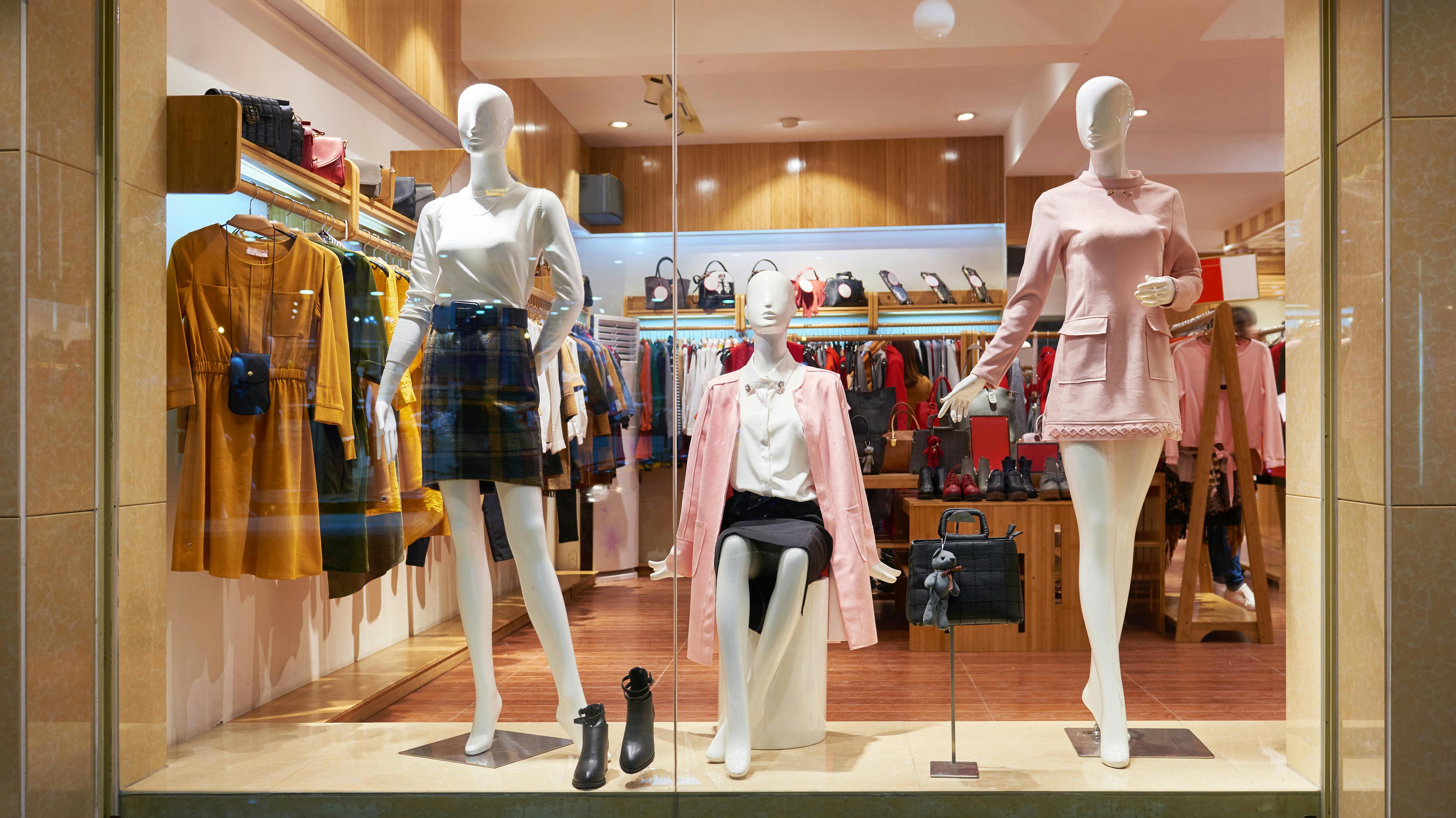 Fashion shop window clothing store front. View of womens fashion clothing store front, Woman mannequin in fashion clothing retail shop window.
