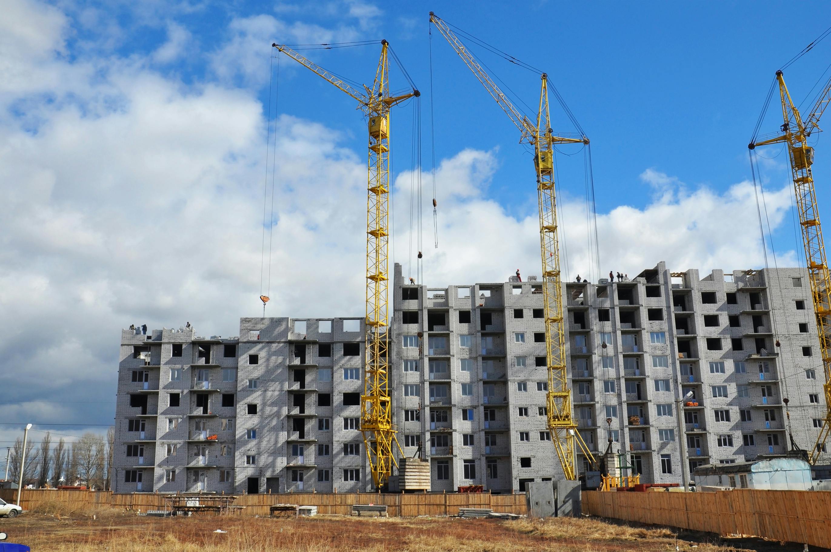Cranes are building new residential district. Apartment building construction cranes on the construction site photo