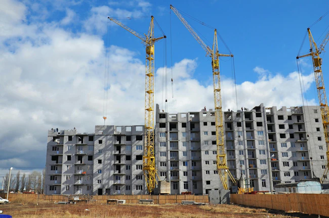 Cranes are building new residential district. Apartment building construction cranes on the construction site photo