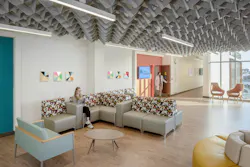 Acoustic materials soften disruptive noise, while diffuse lighting, access to daylight, and views outward help reduce visual stress and support orientation. Image courtesy CannonDesign