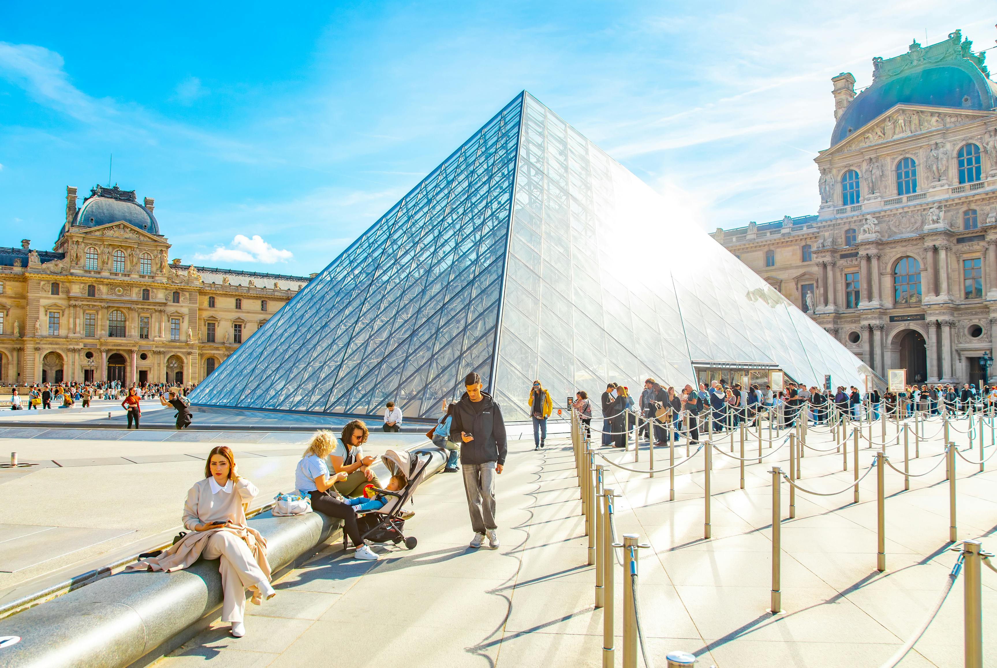 Pyramid entrance to Louvre Museum, Paris. Paris, France - 8 July, 2026: Pyramid main entrance to Louvre Museum, people waiting in a long queue