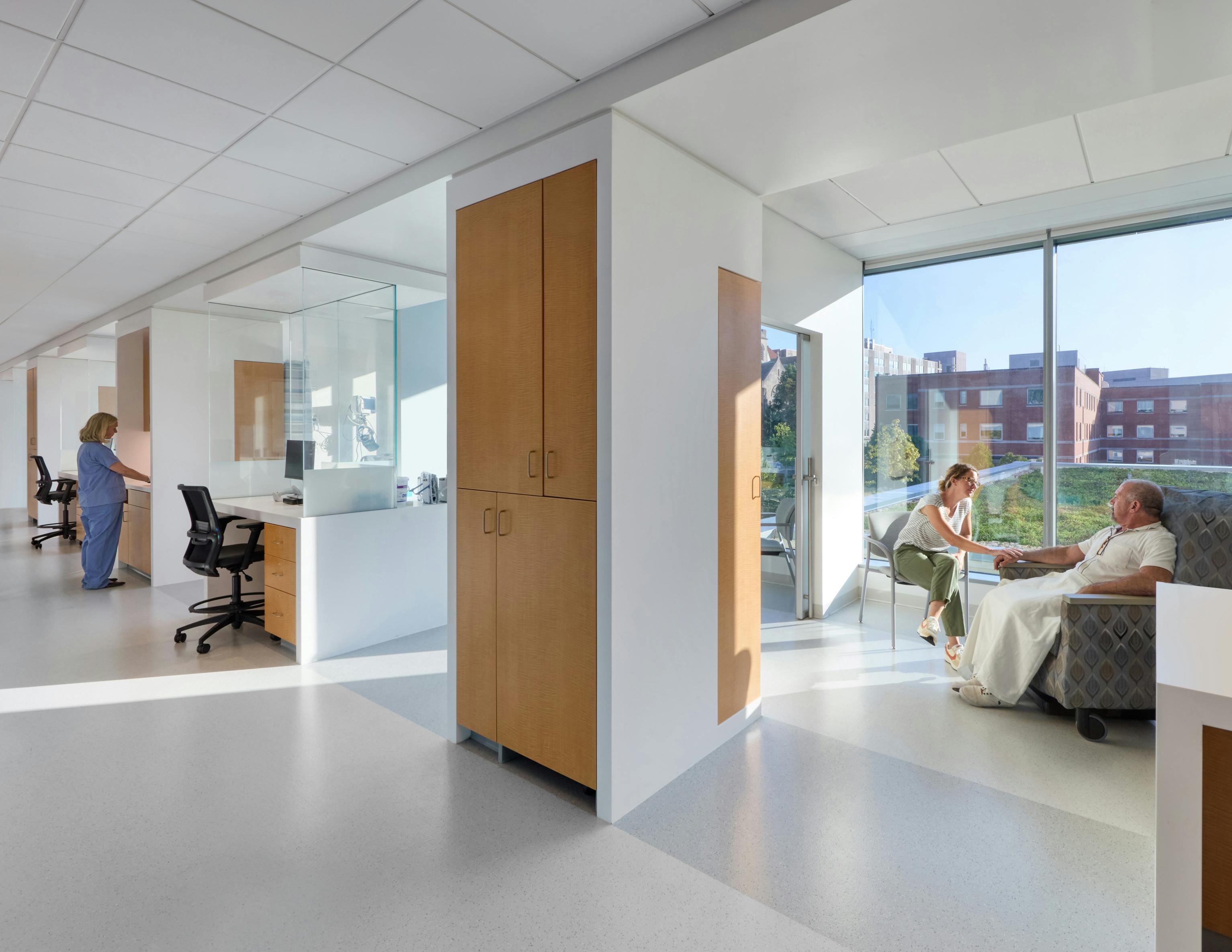 Cancer care patient area with daylight streaming in, private rooms, and light colors